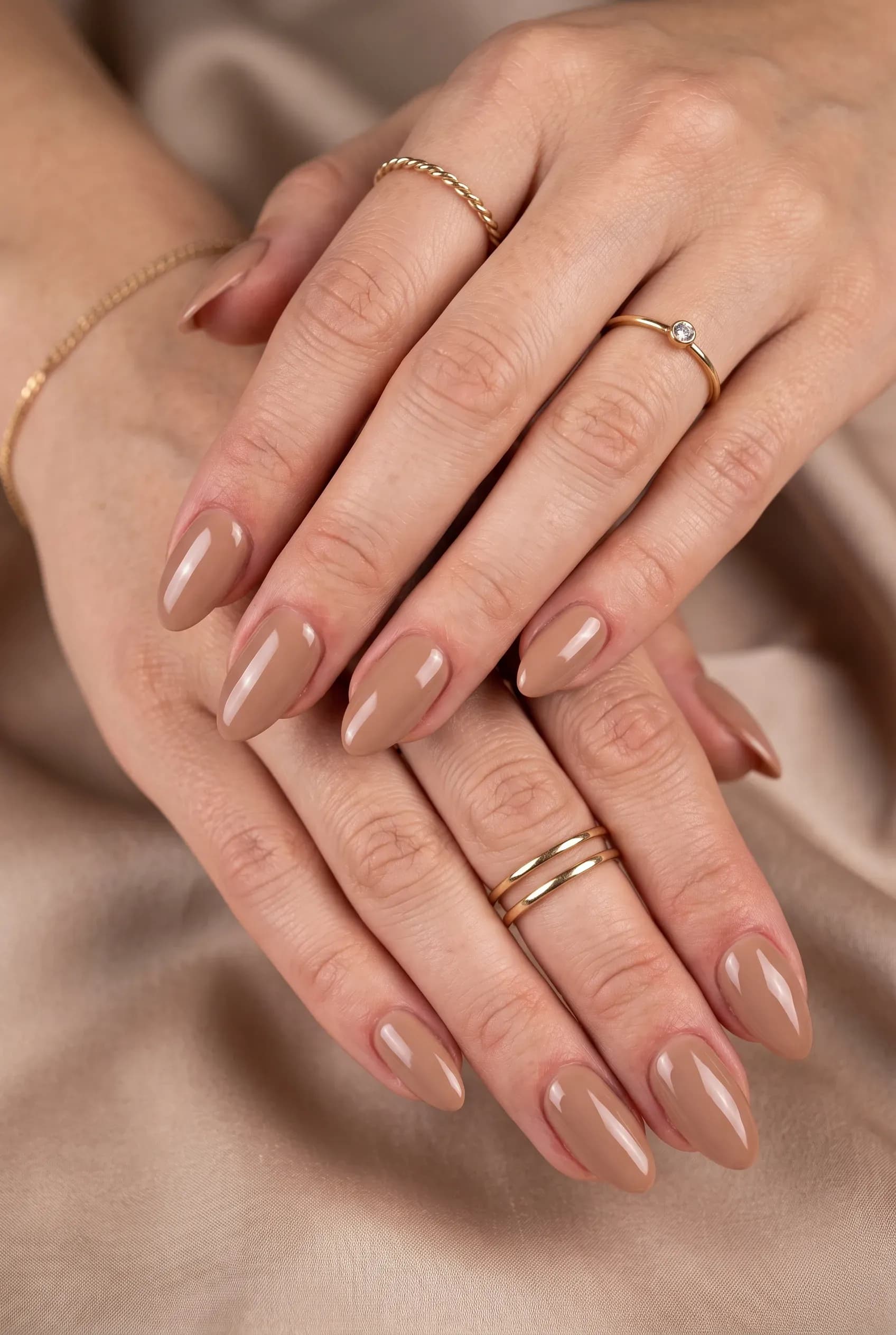 Glossy almond nails in a solid latte brown nude shade